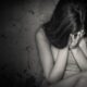 Black and white grunge image of a beautiful teenage girl sitting